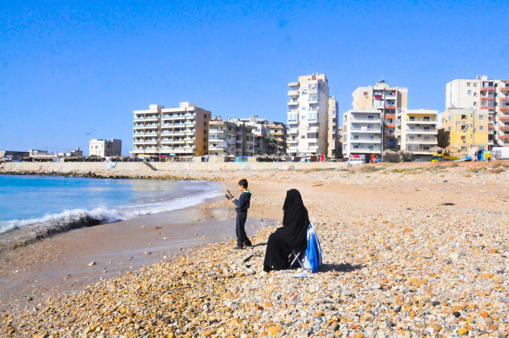 A woman and her son fishing at the beach of Tripoli, Lebanon
