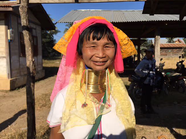 Mujer cuello largo sonriéndole a la cámara, en Loikaw