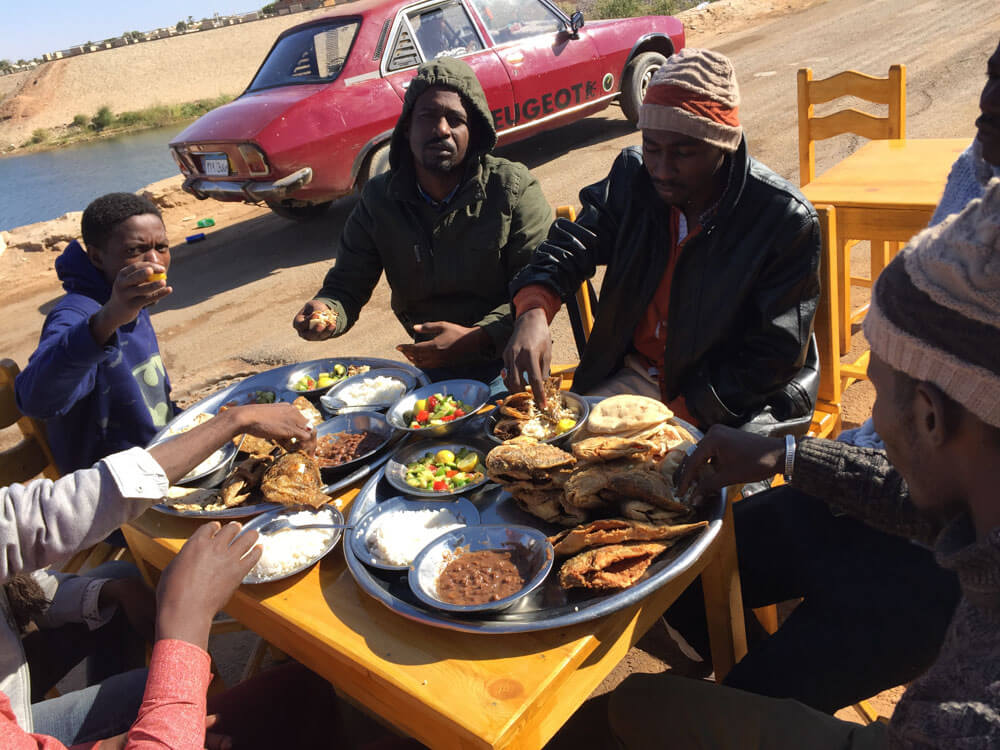 Sudaneses comiendo pescado frito en Abu Simbel