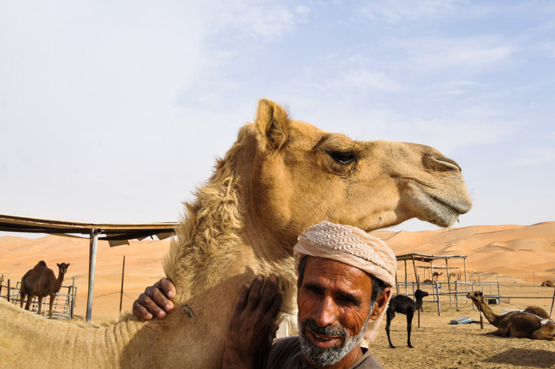 Un beduino emiratí con su camello en Liwa