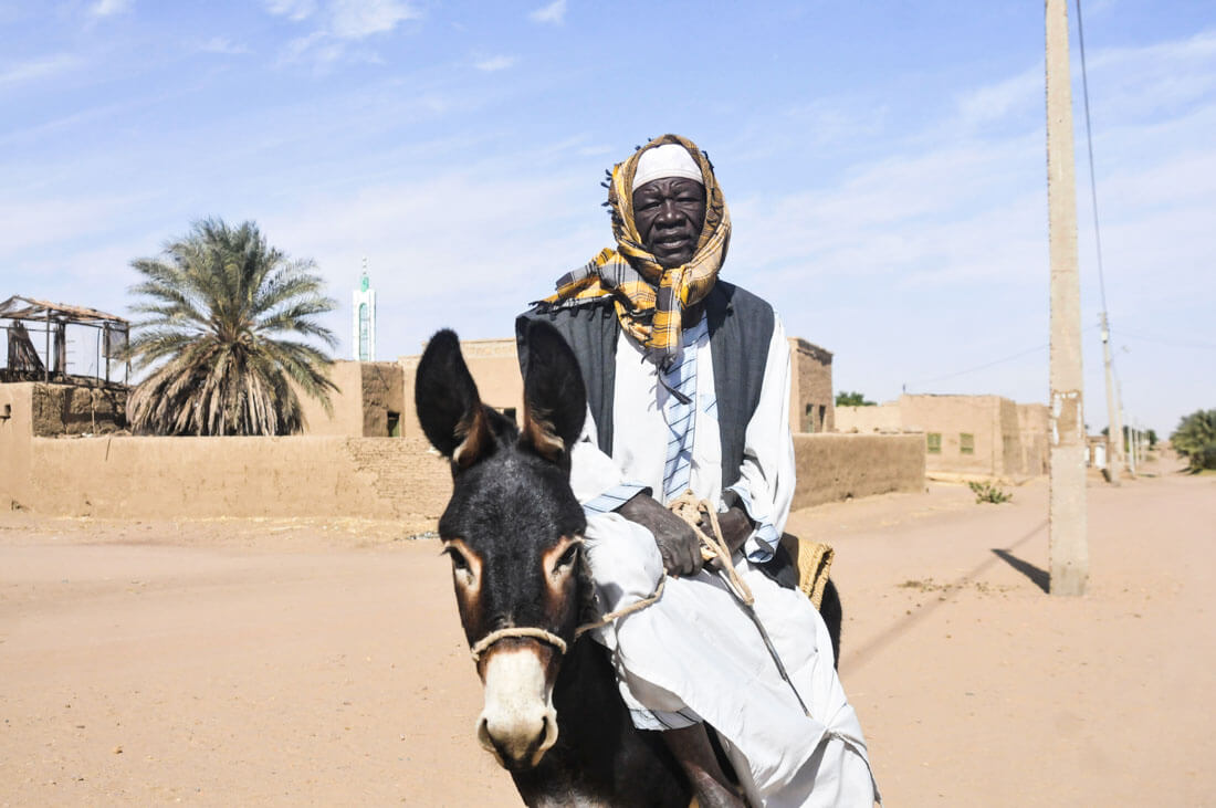 Un sudanés volviendo del mercado con su burro