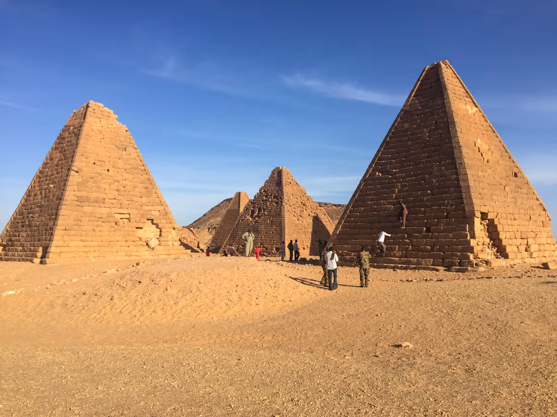The pyramids of Jebel Barkal and some locals climbing them, Karima