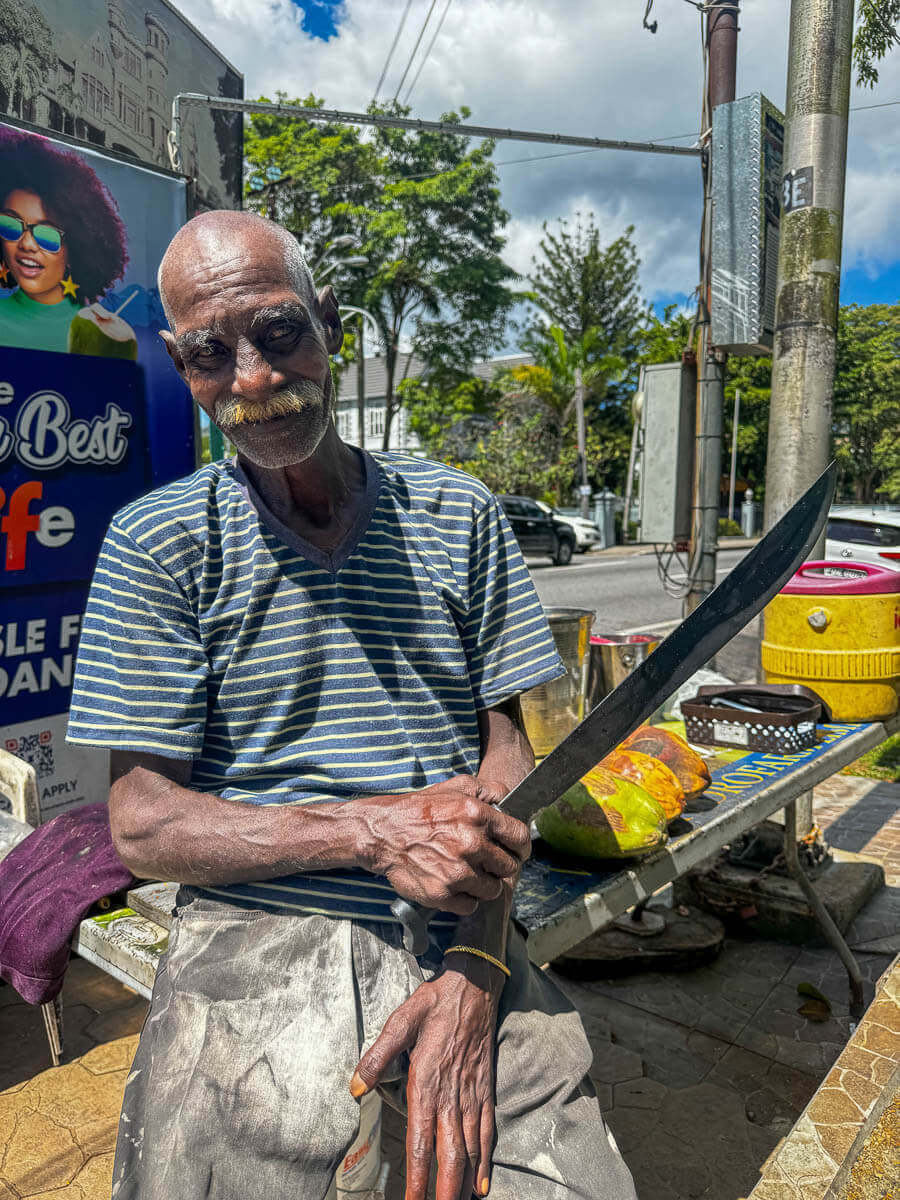Un hombre vendiendo coco en Puerto de España